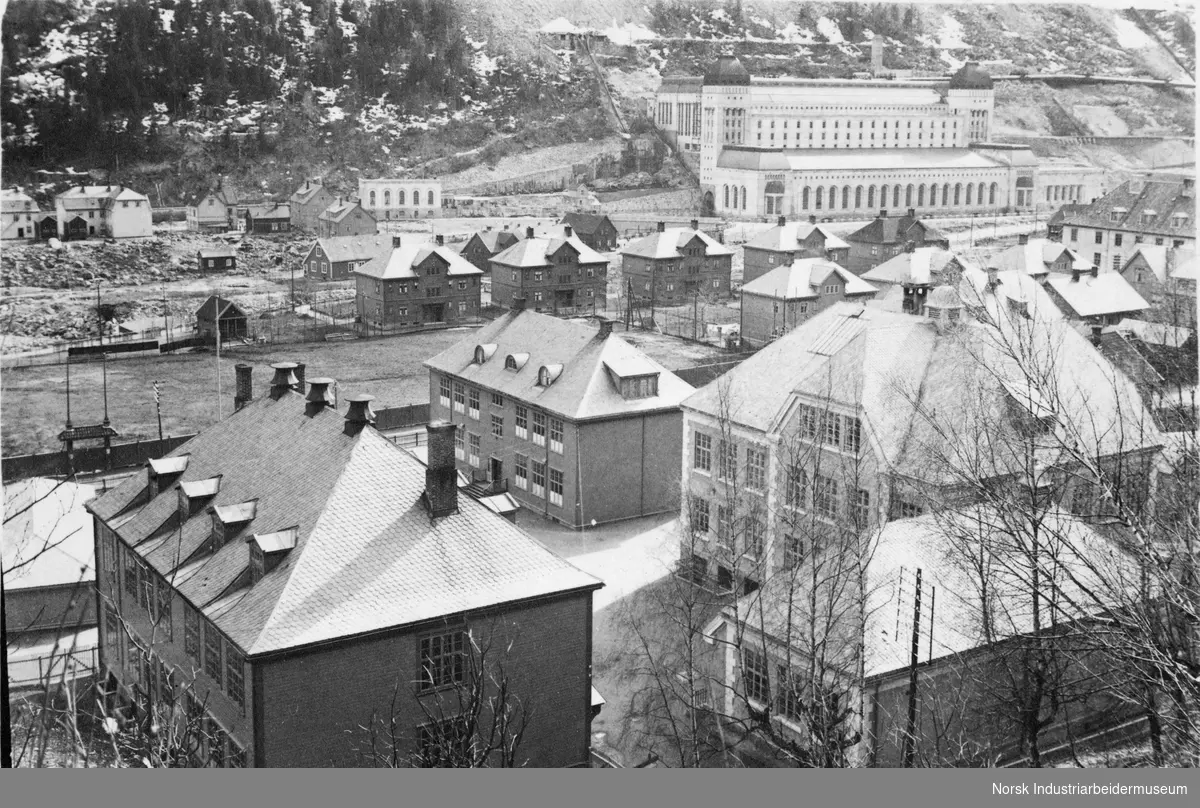 Bebyggelse på industristedet Rjukan. Såheim kraftstasjon oppe til høyre.
Langs nordsiden av Måna er det ensartede leilighetsbygg med ark.