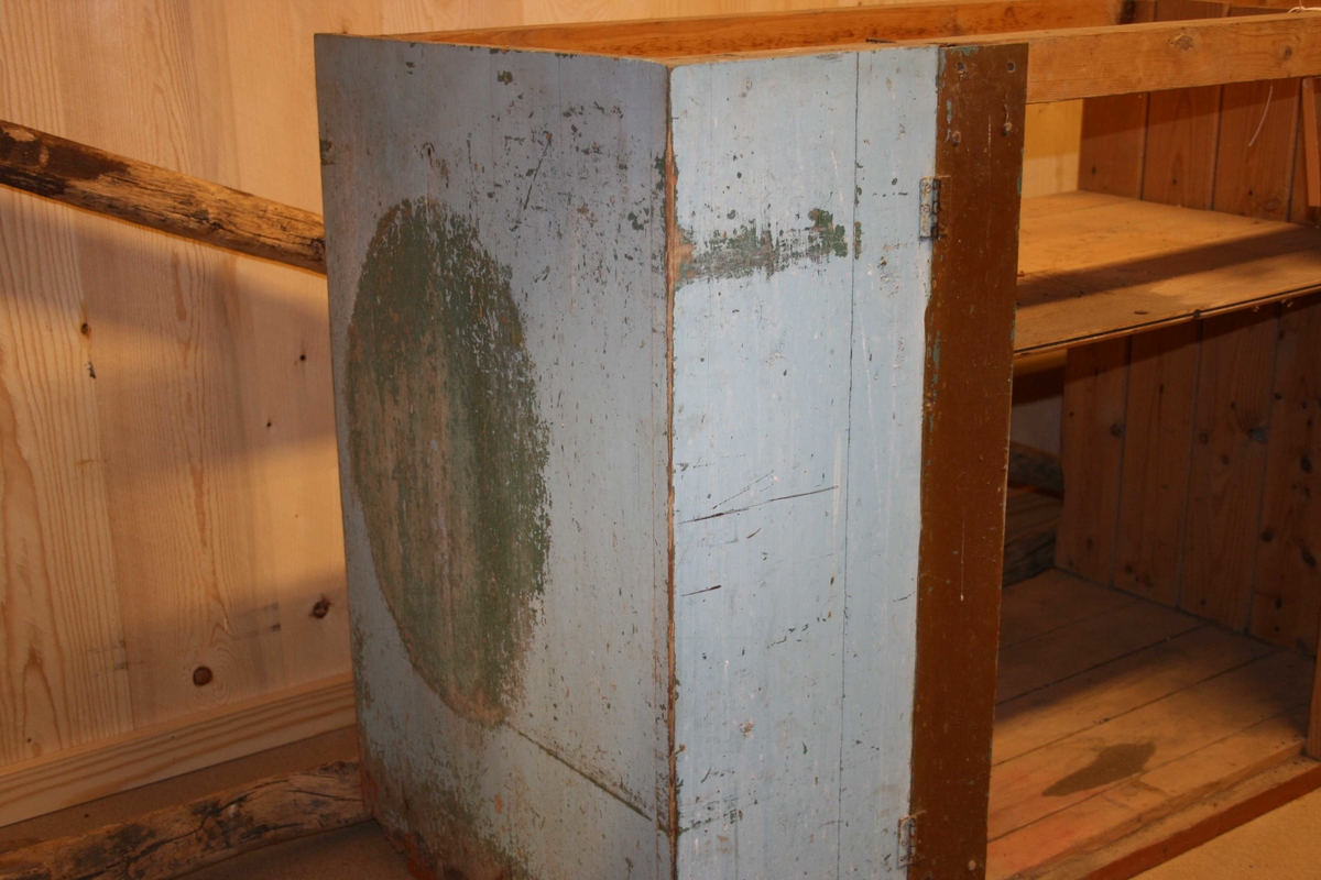 Kjøkkenbenk med to dører og tre skuffer.
Den eine døra er i sund. Ho ligg i delar laust i benken.
To hengsler pr dør. Vridelås av jern.
Skuffene har handtak i stål (ornamentikk).
Skaproma er delt i to med langsgåande hylle. 