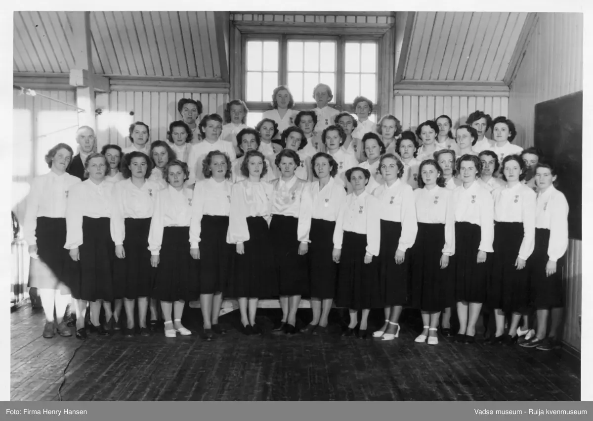 Vadsø Damekor.  Foran fra v.: Mary Bohinen, Astri Brevik, Ella H.Høgsve, Bella Stock?, Ingrid K. Isaksen, Randi Eriksen, Rønnaug Haldorsen, Johanna Schjetne, ? Helfjord, Sofie Klemetsen, Lilla Sjirnov, Asbjørg Jakobsen, ? , Randi Hellander.
2 rekke fra v.; dir. skoledir. Lunde, Åse F. Sæther, Mimmi Dallavara, Ågot Feldt, Ellen Helfjord, Ågot Lohiniva, Alfhid Bohinen, Hulda Feldt, ? Vorren, Bølla Stock, Sina (Hansine) A. Olsen,
3 rekke fra v.; Elsa Warness, Reidun B.Pedersen, Alfhild Ballo, Karin Warness, ukjent, Borghild D. Løkting, ukjent, Mimmi J. Zahl, Klara B. Pettersen, Gerda S. Hoftaniska
Bakerst; Amy Evanger, Alma Seppelæ, Ragni Stock, Elisabeth Esbensen, Martha Hansen, Gulle B. Olsen, Ruth Johansen. (Kilde: tekst på baksiden av bildet 250_2)