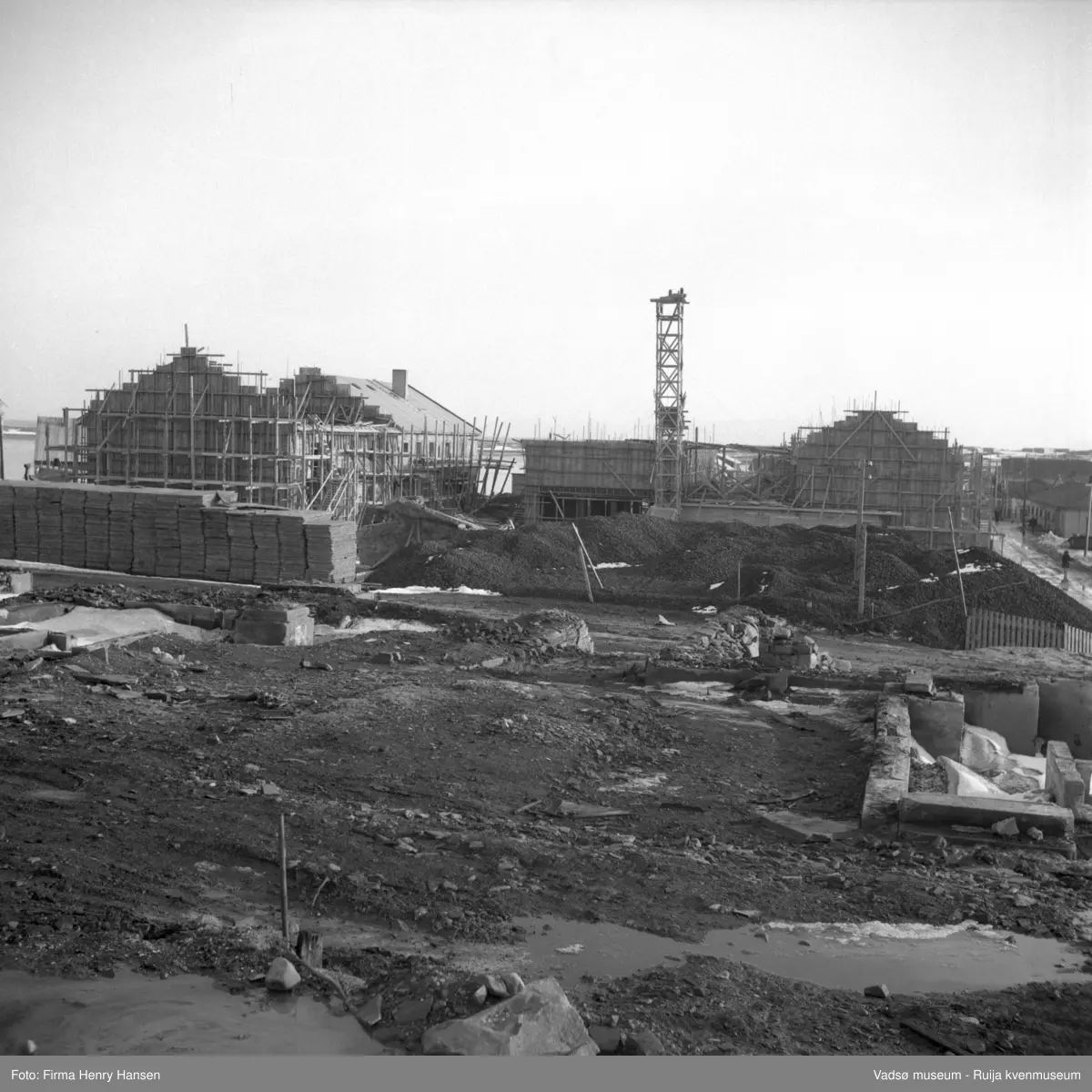 Vadsø sentrum. Gjenreisninga av Sentrum i full gang. Forretningsbyggene rundt Torget, øst for Tollbugata ; bla Rolf Hansen, Henry Hansen, Baker Henriksen under oppføring.
