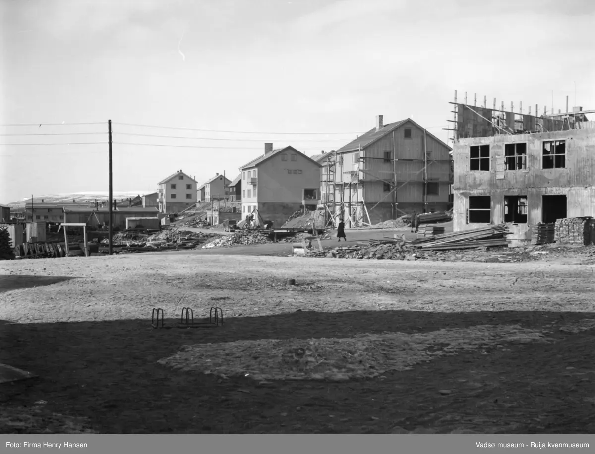 Vadsø mai 1951. På Torget i sentrum, bildet er tatt mot nordvest. Vadsø Rådhus under oppføring. Vest for Tollbugata flere gjenreisningshus. Langs Kaigata ser vi fiskebruk og brakker.