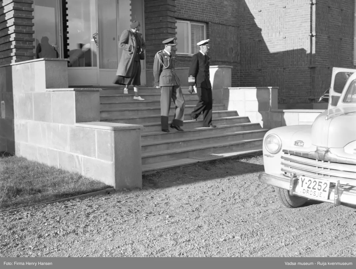 Vadsø. Kongebesøk i Vadsø 1950. Ved Finnmark kringkaster, kronprinsesse Märtha og Kongen forlater bygningen.
Kong Haakon og kronprinsfamilien besøkte Vadsø 25.-26.7.1950 i forbindelse med en større rundreise i Nord-Norge sommeren 1950. Under besøket sto "biltur gjennom byen" og "besøk på sykehuset" på programmet. Kilde: Det kongelige hoff, arkivet