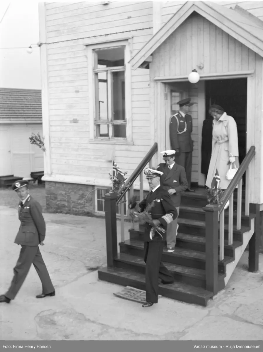 Vadsø. Kongebesøk i Vadsø 1950. Kong Haakon, prins Harald og prinsesse Astrid forlater en bygning. 
Kong Haakon og kronprinsfamilien besøkte Vadsø 25.-26.7.1950 i forbindelse med en større rundreise i Nord-Norge sommeren 1950. Under besøket sto "biltur gjennom byen" og "besøk på sykehuset" på programmet. Kilde: Det kongelige hoff, arkivet
