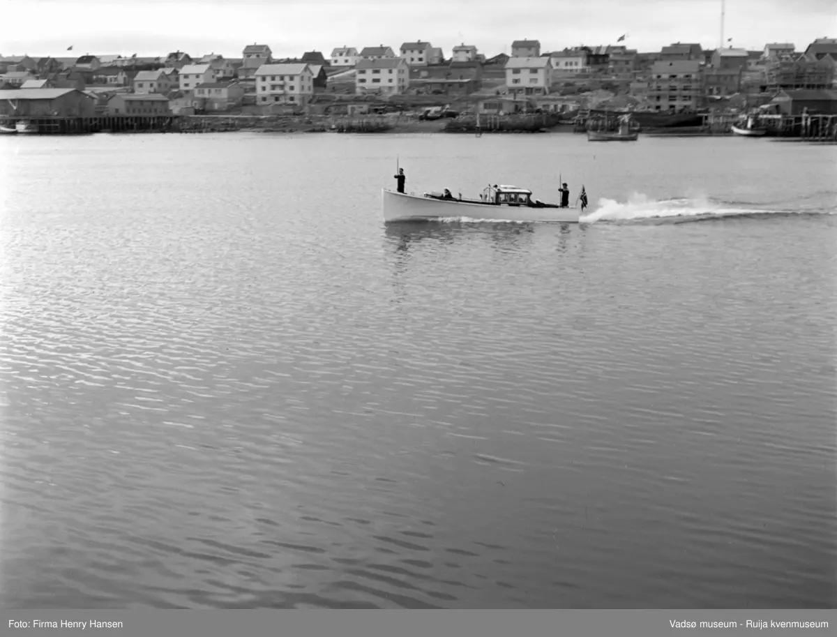 Vadsø. Kongebesøk i Vadsø 1950. Sjalupp på tur fra Vadsø havn og ut til kongeskipet.
Kong Haakon og kronprinsfamilien besøkte Vadsø 25.-26.7.1950 i forbindelse med en større rundreise i Nord-Norge sommeren 1950. Under besøket sto "biltur gjennom byen" og "besøk på sykehuset" på programmet. Kilde: Det kongelige hoff, arkivet