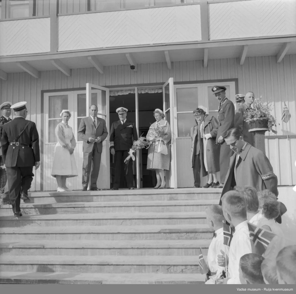 Vestre Jakobselv juli 1959. Kongen på trappa til barnehjemmet Vårsol. Til venstre for Kongen : søster Gunvor og ordfører Henry Karlsen; til høye for Kongen: prinsesse Astrid