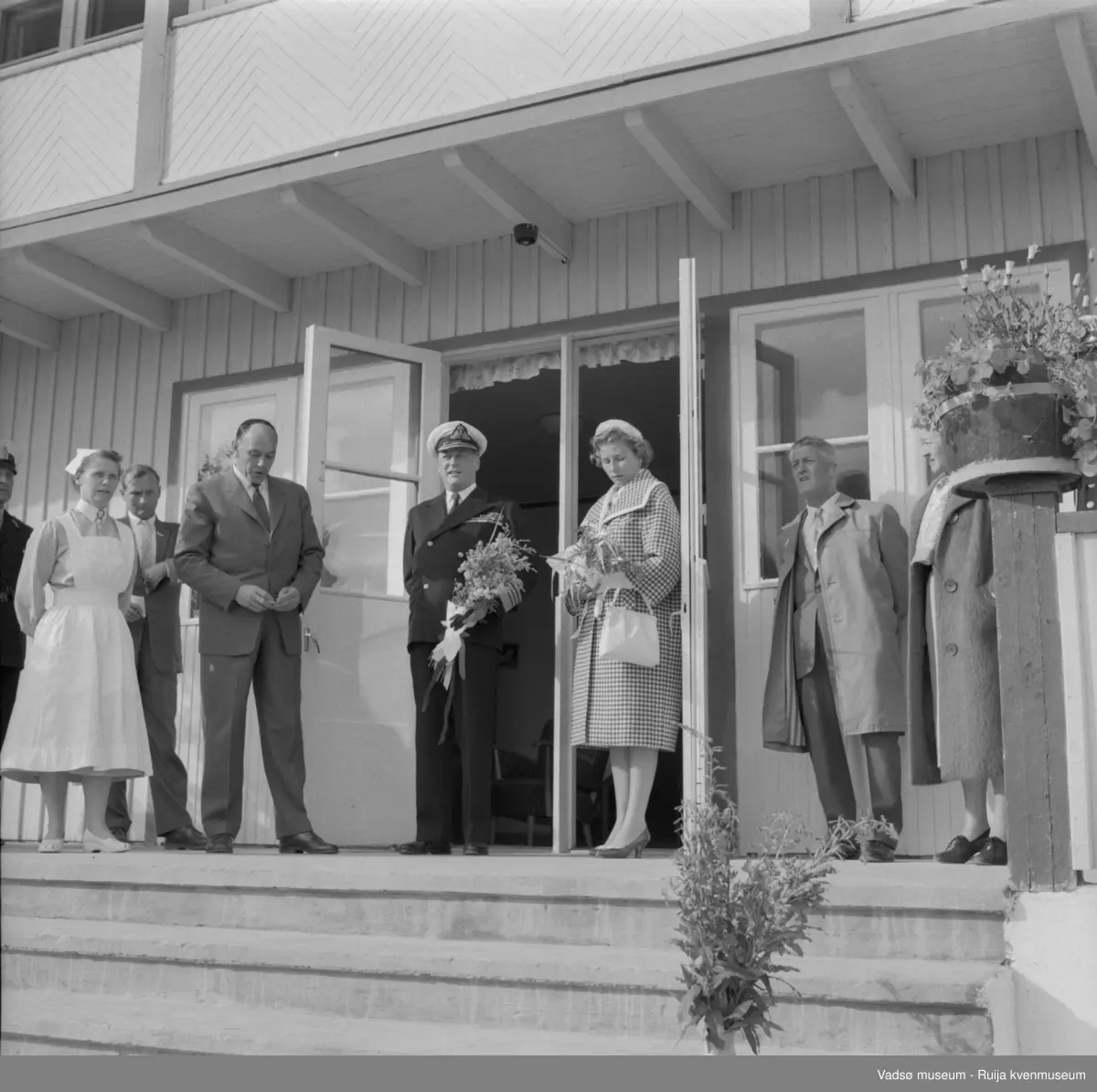 Vestre Jakobselv juli 1959. Kongen på trappa til barnehjemmet Vårsol. Til venstre for Kongen : søster Gunvor og ordfører Henry Karlsen; til høye for Kongen: prinsesse Astrid og fylkesmann Peder Holt.
