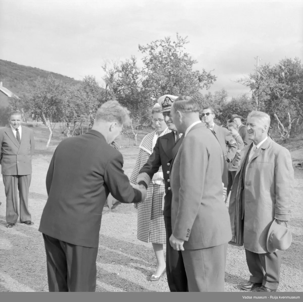 Vestre Jakobselv juli 1959. Kongebesøk på barnehjemmet Vårsol.  Kongen hilser på Anaton Strand. Ytterst til venstre Gunnar Harila. Til venstre for Kongen prinsesse Astrid. Til høyre ordfører Henry Karlsen og fylkesmann Peder Holt.
