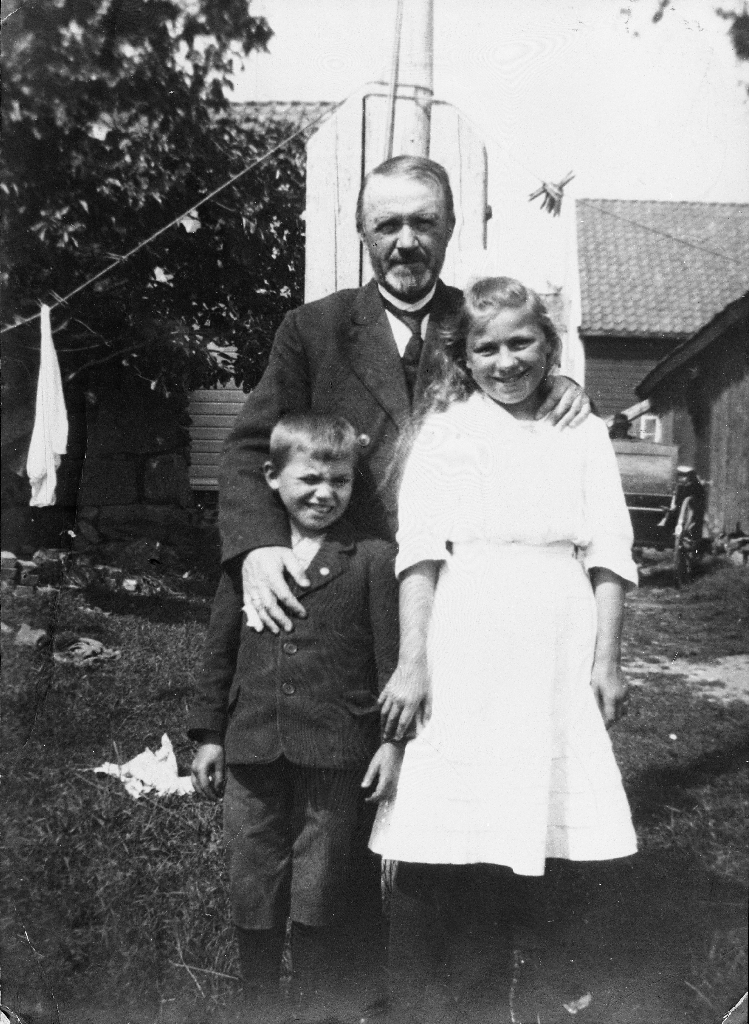 Eivind Hognestad med to tyske krigsbarn frå Berlin, søskena Heinz og Klara Werner. Biletet er teke på ein søndag. Til høgre ser me litt av trilla som står framme til kyrkjeferd.