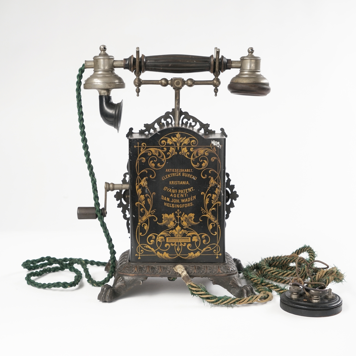 Telefonapparat med koblingsskive. Sort og gull med forsiringer.