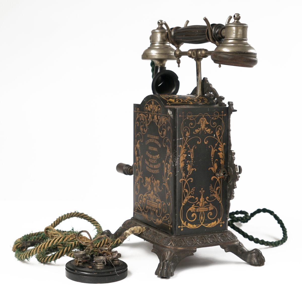 Telefonapparat med koblingsskive. Sort og gull med forsiringer.