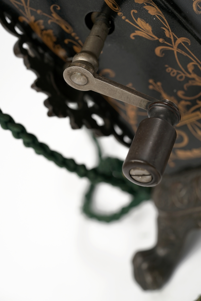 Telefonapparat med koblingsskive. Sort og gull med forsiringer.