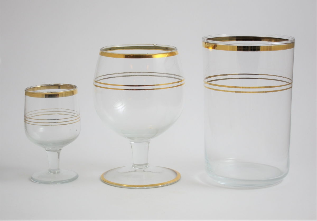 Likörglas.
Kupan sluter sig svagt mot mynningen. Tre målade guldlinjer på kupans mitt. Målad guldrant runt mynning.