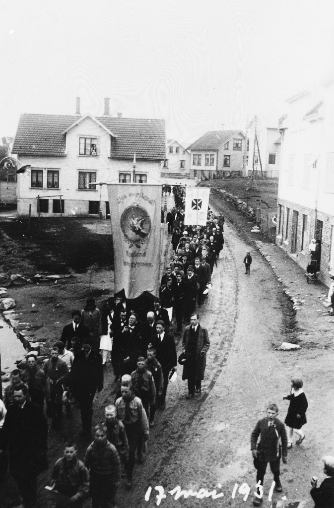 17. mai tog på Bryne i 1931 aust for noverande jernbaneundergang i Arne Garborgs veg. Fremst går speidergutter, etter første fane går lærarane ved Rogaland off. lansgymnas.