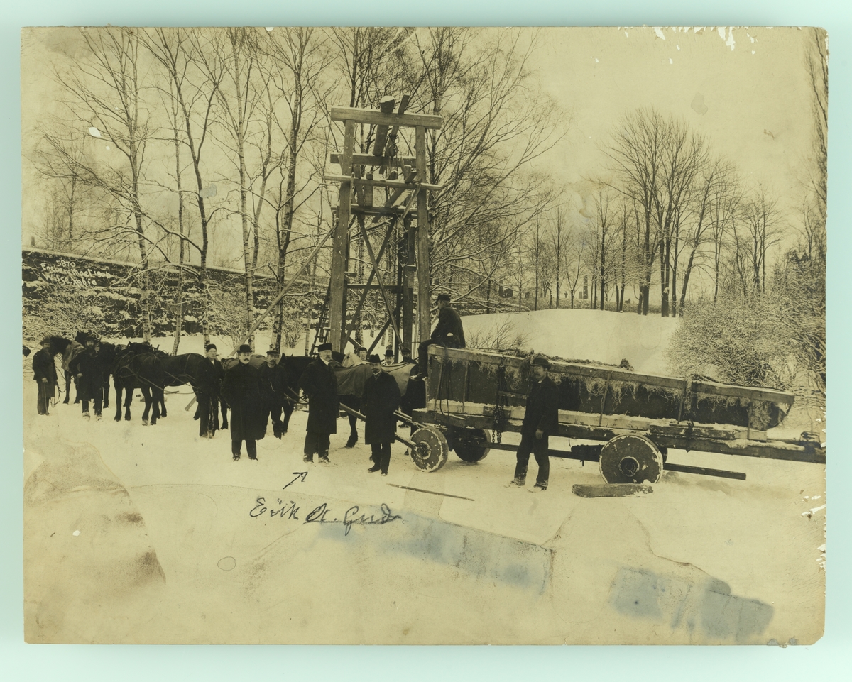 Henrik Ibsens gravmonument (obelisk) transporteres til Vår Frelsers gravlund. Eirik A. Gude sammen med arbeidere.