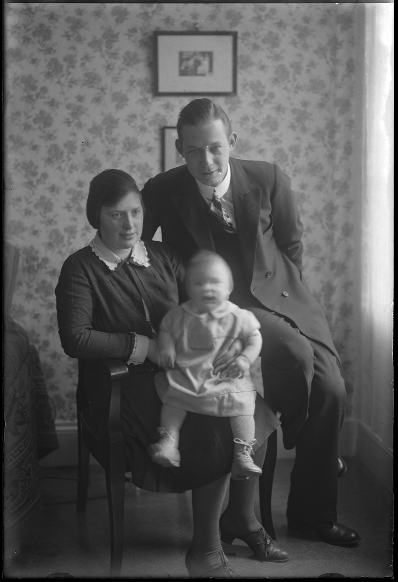 En familj, bestående av mamma, pappa och barn, fotograferade tillsammans. I fotografens egna anteckningar står det "Paul Anderssons familj". Tolkat som Paul Andersson (f. 1901), Rut Naemi Svensson (f. 1903) och dottern Gunvor Linnéa Andersson (f. 1929)