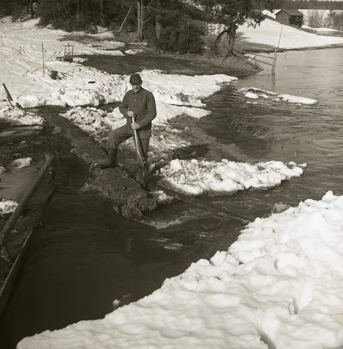 En man står vid en vårflödande å i Torsbro den 28 april 1965.