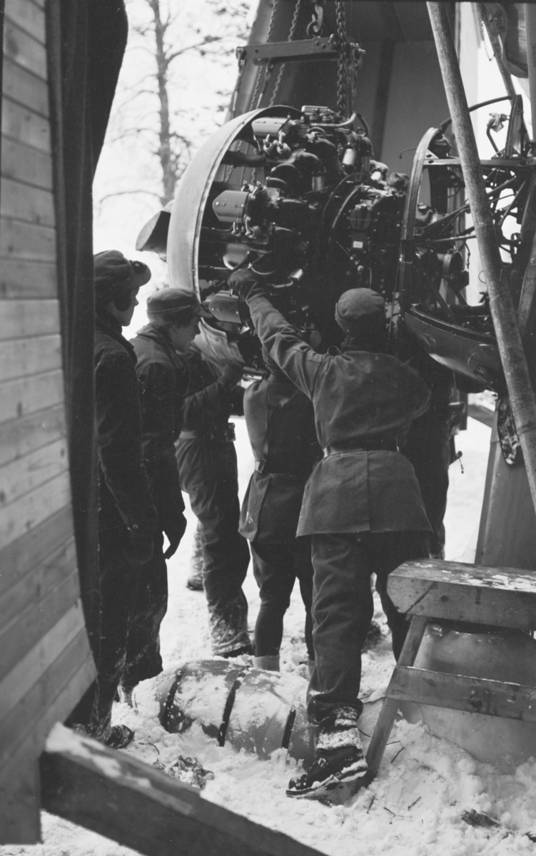 Arbete med motor på flygplan Gloster Gladiator vid F 19, Svenska frivilligkåren i Finland. Fem mekaniker i arbete.