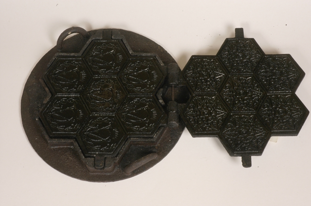 Relieffstøpt figur som inneholder G, V, krone og grener og stjernedekor.