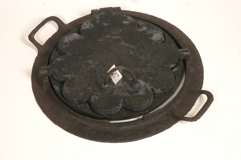 Vaffeljernet er av støpt jern og består av to like plater, svingbart med en tapp på hver side som går ned i spor på ringen, hvor jernet er hengslet til bak. Flat ring tilpasset jernet med to bueforma håndtak. Ett håndtak opp på lokket, framme. Mønster innvendig med fem hjerteforma kaker.