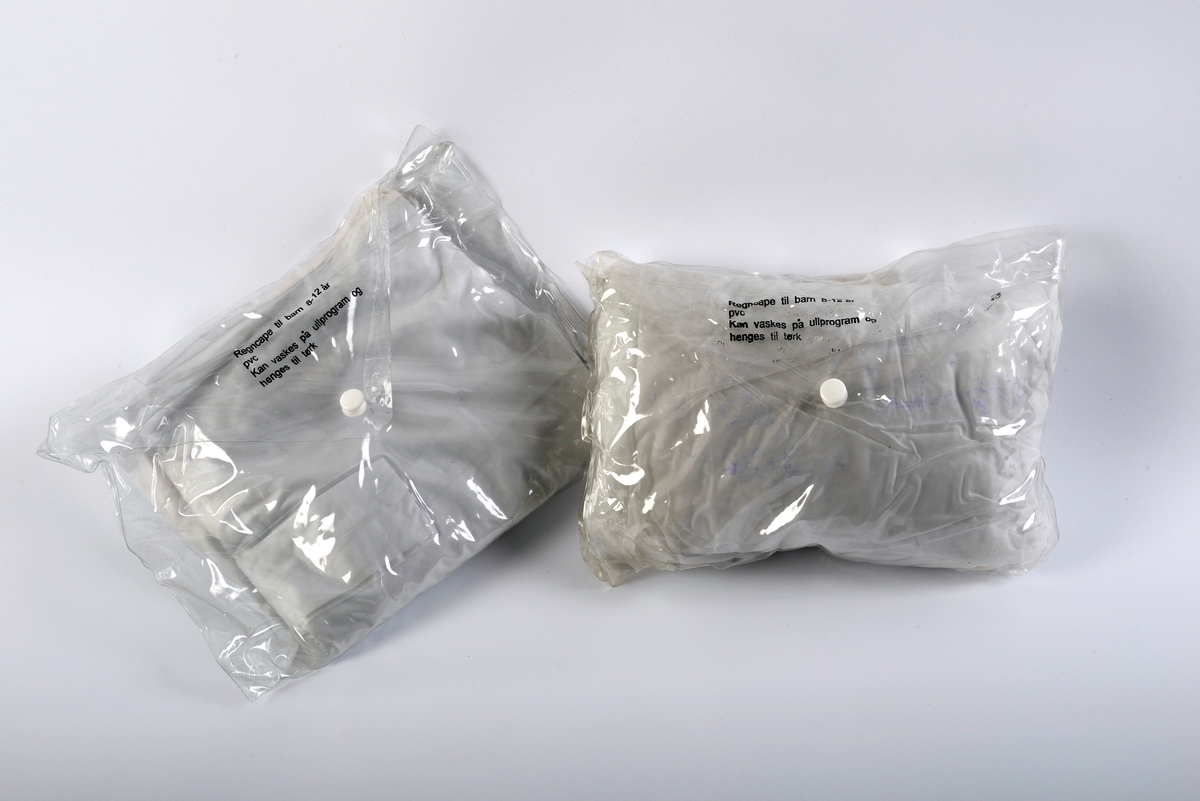 Regncape i plast, med pose.

For fullstendig historikk om bunad som denne gjenstanden inngår som del av, se KMR.3684.