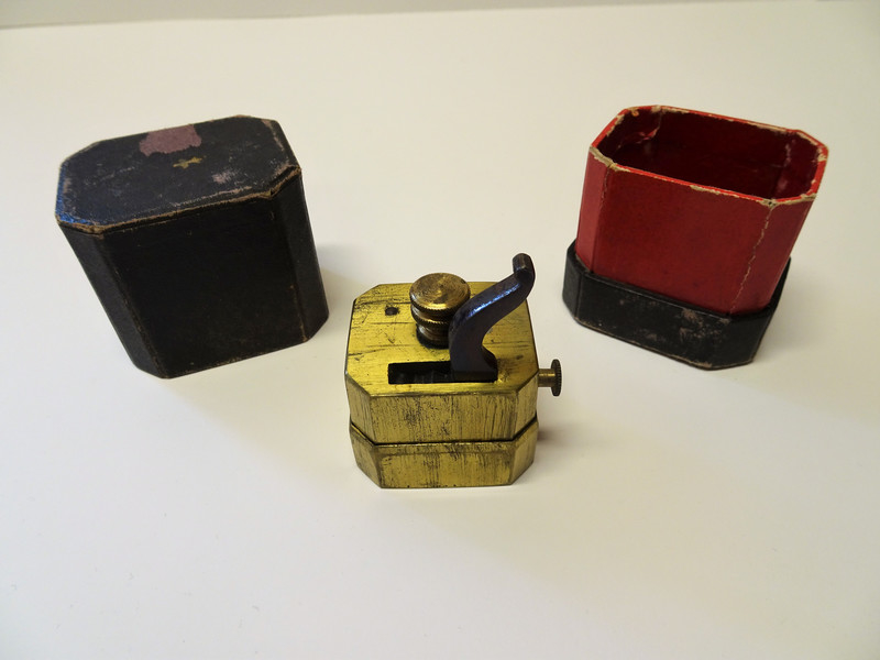 Årelatingsinstrument i metall med tilhørende åttekantet oppbevaringsboks.
 
Instrumentet består av en liten messingkasse med 12 kniver som spennes samtidig med en kraftig fjær koblet til en hane på toppen av kassen. En skrue ved siden av hanen justeres for å oppnå ønsket dybde. En liten knapp på siden av apparatet utløste knivene når instrumentet var plassert der årelatingen skulle gjennomføres, ofte på innsiden av armen.
