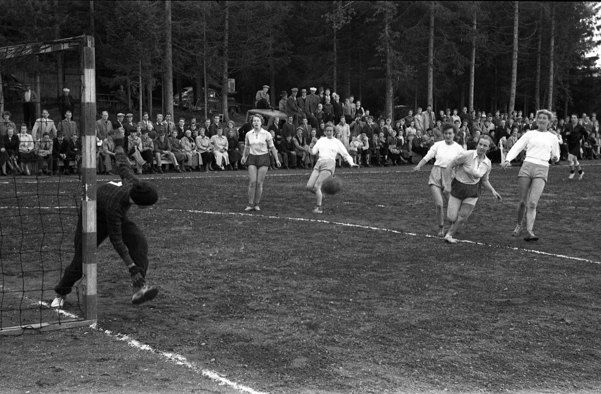 Håndballkamp på Kraby Idrettsplass september 1953. Kampen var kvartfinale i damenes Norgesmesterskap mot Nornen fra Bergen, en kamp Kraby vant og dermed kvlifiserte seg for semifinale. Krabys spillere, i de mørkeste buksene, er identifisert, men for navn henvises til lagbilde TMF-06483.
14 bilder som viser kampsituasjoner og publikum.