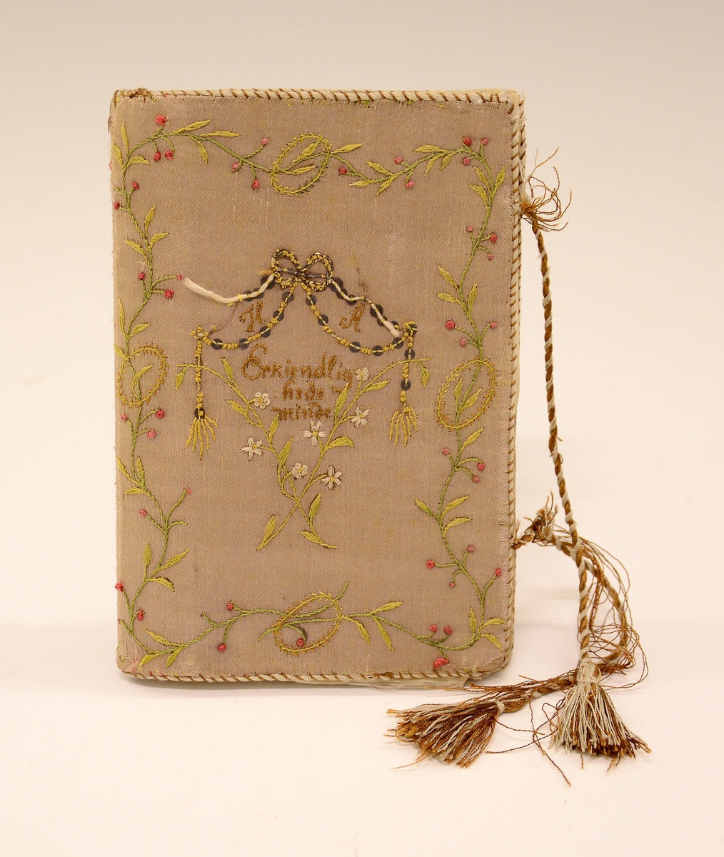 Lommebok i silke med brodert motiv og tekst. Innvendig med tre rom. Permane paaføra med gult og violet silkety med blomebrodering  paa utsidane. Paa framsida stend sauma: H.A. - Erkjendlighedsminde. Paa baksida eit tre, innaat dette eit ankar. Tvunnet silkeband.