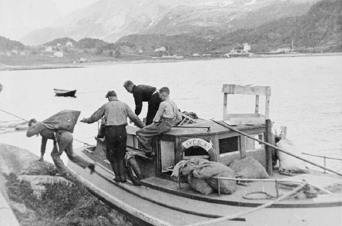 Leirfjord, Leira. Tyske soldater losser brensel (ved og kull) fra motorbåten "Vesla". (eier er Martin Edvardsen) - tyskerene rekvirerte båten! De hadde forlegning på skolehuset i Leira - Leira skole.
Bildet er brukt i Leirfjordkalenderen - september 1997