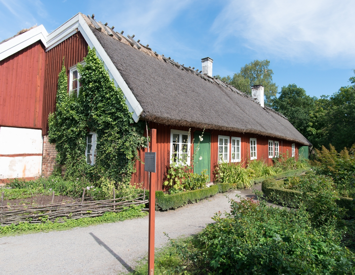 Bostadshuset på Skånegården är uppfört i en våning och klädd med stående locklistpanel som målats med röd slamfärg. Byggnaden har ett sadeltak klätt med halm. Skorstenarna är två, en placerad på nock och en i takfallet ut mot trädgården.

Bostadshuset flyttades till Skansen 1974 från gården Hög 18:1, Högs socken i Skåne. På Skansen visas hur byggnaden såg ut under 1920-talet.