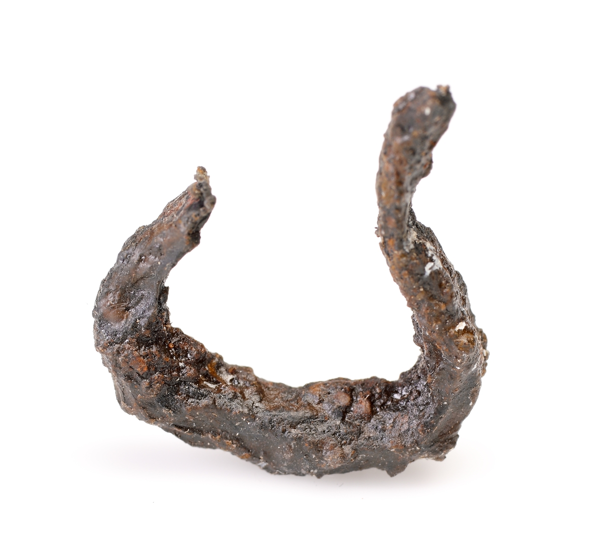 Del av en mungiga. Endast bågen och ansats av ena skänkeln bevarad. Starkt vittrad.