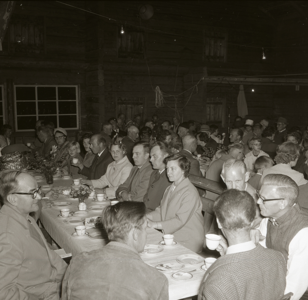 En grupp människor sitter i långbord vid Hembygdsföreningens festbjudning, 1 september 1962 i Rengsjö.