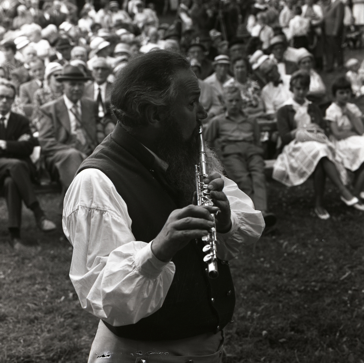 Under hembygdsfesten i Rengsjö lyssnar publiken på toner från en spelman med flöjt, 16 juli 1961.