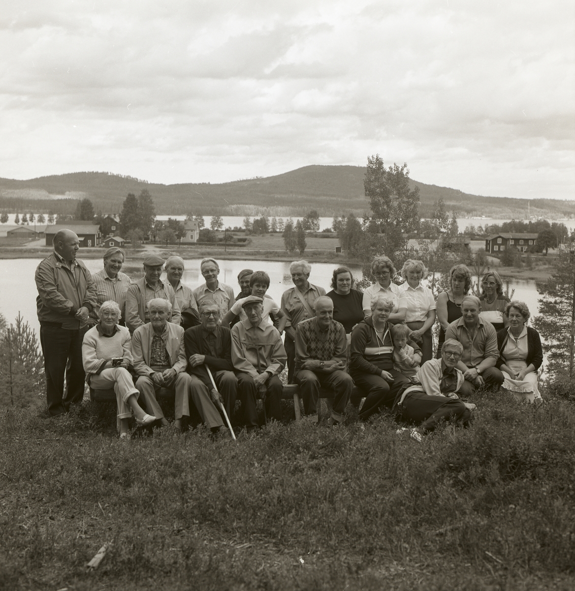 En gruppfotografering med deltagarna vid en byvandring i Östra Höle. Fotografiet togs vid Hölesjön den 27 augusti 1983.