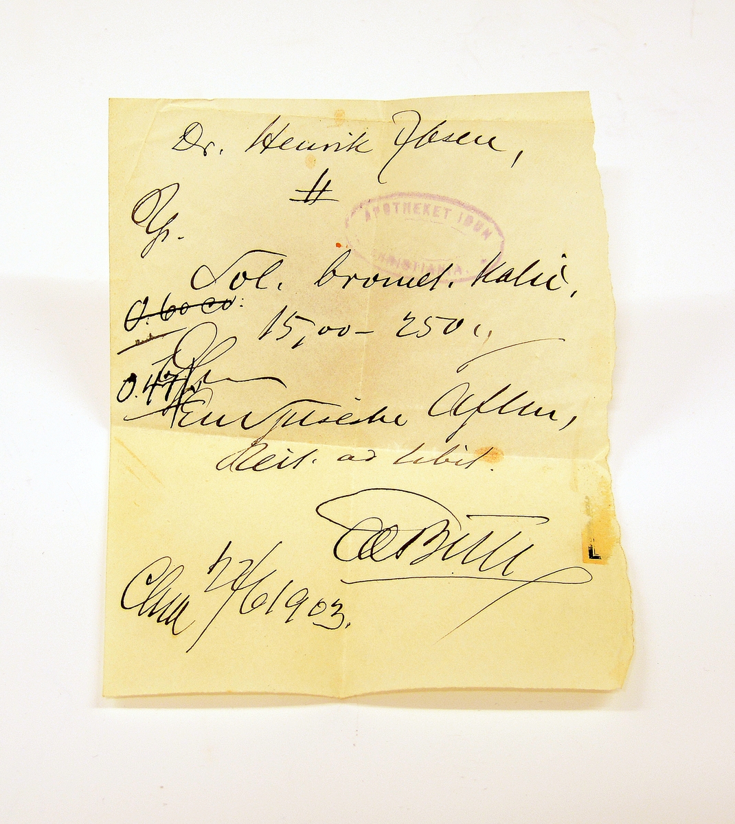 Liten lommebok i grønt skinn med to rom, mosegrønt fôr. Utsiden med preget dekorrender i gull. En side mangler sømmen.
Innlagt konvolutt med to resepter fra Henrik Ibsens privatlege, Dr. med. Edvard Bull. Den ene resepten datert 14/3 1903. En tredje resept, italiensk, datert 31. mai 1897.