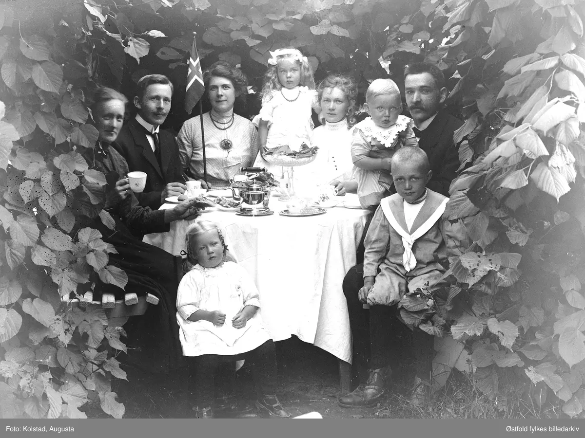 Kaffeslabberas utendørs i hagen, med ukjent familiegruppe rundt bordet.