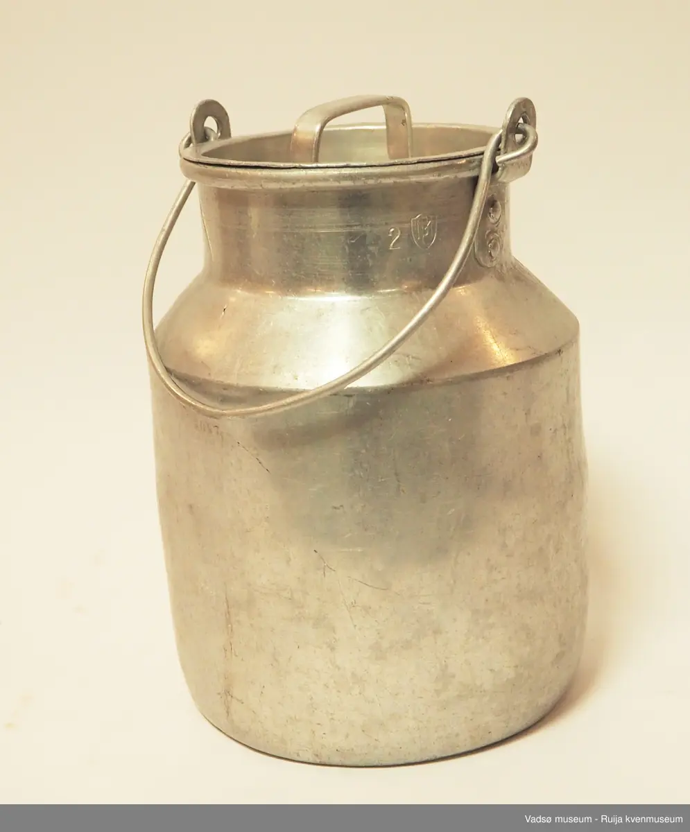 Sylinderformet aluminumsbeholder til oppbevaring og transport av melk. Spannet har hals, hengslet hank og lokk med håndtak. Kapasiteten til melkespannet er på 2 liter.
