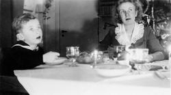 Kvinne og barn til bords i juleselskap.