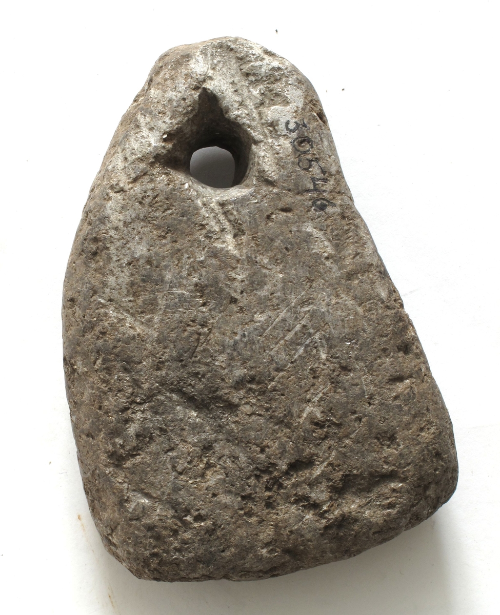 Kljåstein av kleber, av noe uregelmessig trekantet form. Bærehullet i toppunktet. Grovt tildannet, men bra bevart. Lengde 11,5 cm, st. bredde 8 cm.