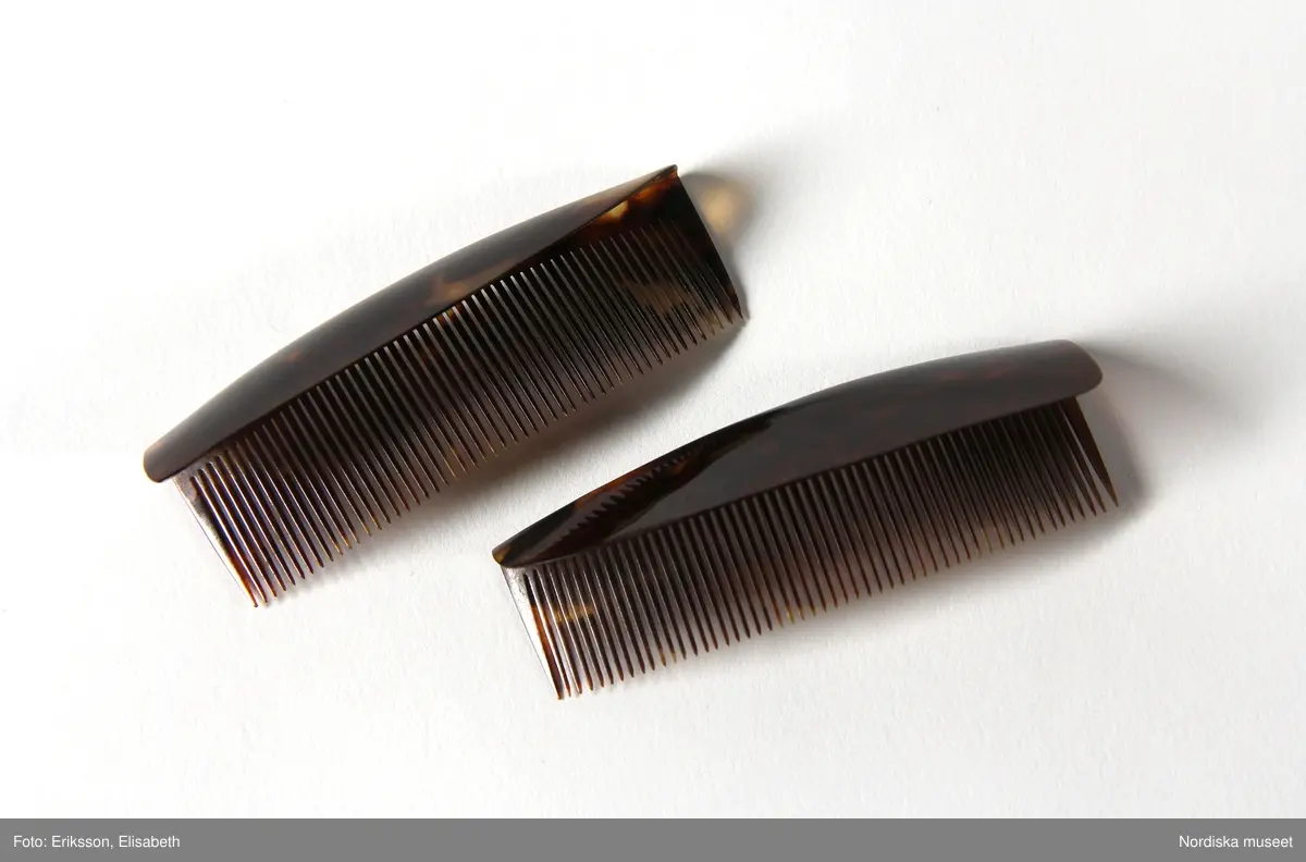 Huvudliggaren:
"Kammar. Af äkta sköldpadd. Tillh. drottning Josefina.
a. Benkam. 
b. Friserkam.
c:1-2  [2 st, L 7,6 cm]
d [L. 12,6 cm]
e [L. 6,3 cm.]
Ink. af f.d. garderobièren hos drottning Josefina, fröken Vilhelmina Åhman, jämte 13701. Ankom 17/10 1876."

c:1) L. 7,6 cm
c:2) L. 7,6 cm
d) L. 12,6 cm 
e) L. 6,3 cm.