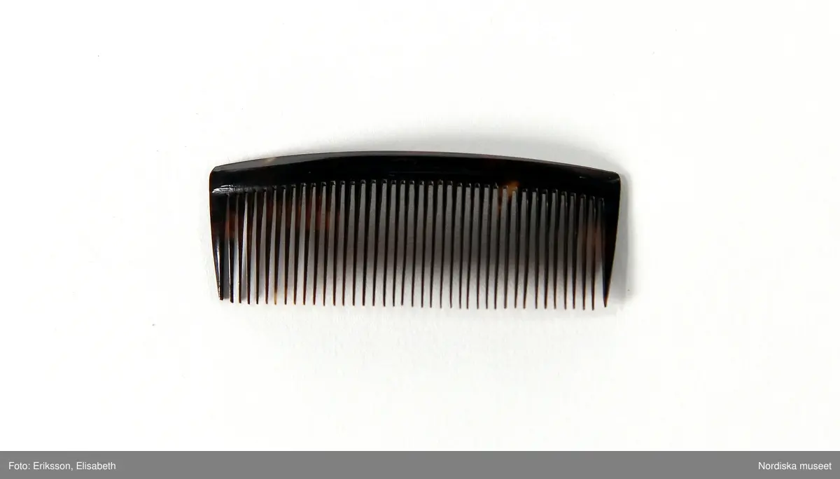 Huvudliggaren:
"Kammar. Af äkta sköldpadd. Tillh. drottning Josefina.
a. Benkam. 
b. Friserkam.
c:1-2  [2 st, L 7,6 cm]
d [L. 12,6 cm]
e [L. 6,3 cm.]
Ink. af f.d. garderobièren hos drottning Josefina, fröken Vilhelmina Åhman, jämte 13701. Ankom 17/10 1876."

c:1) L. 7,6 cm
c:2) L. 7,6 cm
d) L. 12,6 cm 
e) L. 6,3 cm.