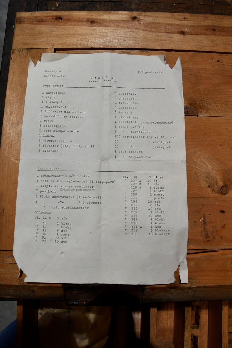 Kasse med lokk på siden som kan åpnes. Under lokket er det to skuffer med innhold som kan trekkes ut. Inneholder loddkasse, balansevekt, 10 stempler, postskilt i seilduk, postveske, sammeleggbar stol, penge-frimerkeskrin og innholdsliste.