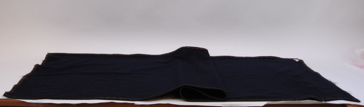 Ett draperi av mörkblå filt med en kringgående fastsydd bård. Bården har en enkel dekor som består av blå och svart tråd som vilar mot en textil som är röd/purpur färgad. Tyget är blekt.

Överst på draperi har det en gång suttit sex stycken fästen för att kunna hänga upp draperiet. Fästena finns idag inte kvar men man kan se var de har suttit. Längst ner på draperiet kan man se att draperiet är skarvat och att där sitter ett likadant tygstycke som draperiet är gjort av men att det är betydligt mindre blekt. Det kan hända att gardinen är förlängd eller att en nött bit, som har släpat i golvet, har klippts bort och ersatts.