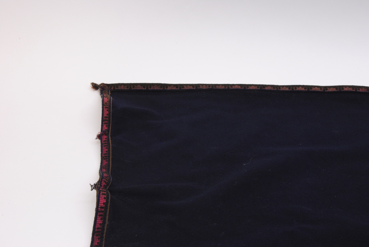 Ett draperi av mörkblå filt med en kringgående fastsydd bård. Bården har en enkel dekor som består av blå och svart tråd som vilar mot en textil som är röd/purpur färgad. Tyget är blekt.

Överst på draperi har det en gång suttit sex stycken fästen för att kunna hänga upp draperiet. Fästena finns idag inte kvar men man kan se var de har suttit. Längst ner på draperiet kan man se att draperiet är skarvat och att där sitter ett likadant tygstycke som draperiet är gjort av men att det är betydligt mindre blekt. Det kan hända att gardinen är förlängd eller att en nött bit, som har släpat i golvet, har klippts bort och ersatts.