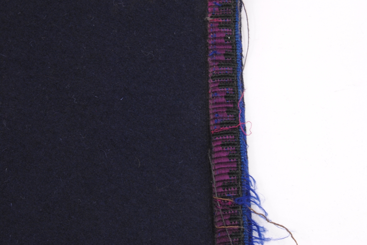 Ett draperi av mörkblå filt med en kringgående fastsydd bård. Bården har en enkel dekor som består av blå och svart tråd som vilar mot en textil som är röd/purpur färgad. Tyget är blekt.

Överst på draperi har det en gång suttit sex stycken fästen för att kunna hänga upp draperiet. Fästena finns idag inte kvar men man kan se var de har suttit. Längst ner på draperiet kan man se att draperiet är skarvat och att där sitter ett likadant tygstycke som draperiet är gjort av men att det är betydligt mindre blekt. Det kan hända att gardinen är förlängd eller att en nött bit, som har släpat i golvet, har klippts bort och ersatts.