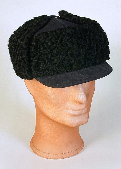 Sportmössa för man av blått ylletyg, kilskuren kulle. Tygklädd skärm. Uppvikt brätte klätt med krimmer. Påsydd prislapp. 
Mått: Runt kullen 590 mm. Kullens höjd 90 mm. 
Storlek: 61.