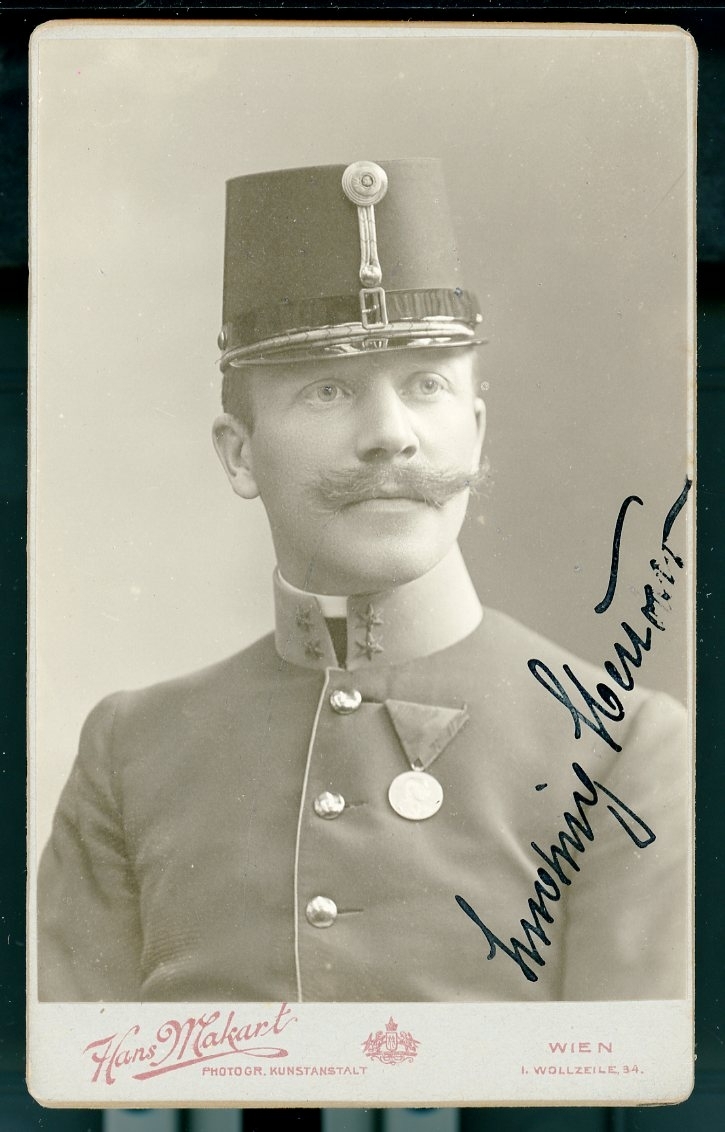 Kabinettsfotografi: Österrikisk-ungersk officer med mössan på huvudet och medalj på bröstet. Hans namn är svårt att tolka.