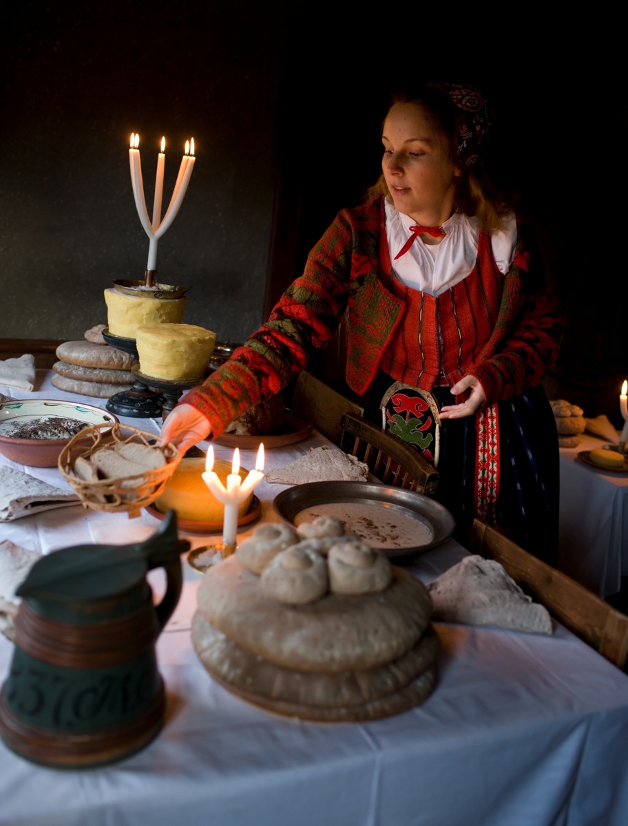 Interiör från en Skansenmiljö. Dukat julbord i Delsbogården, pedgagog klädd i folkdräkt.