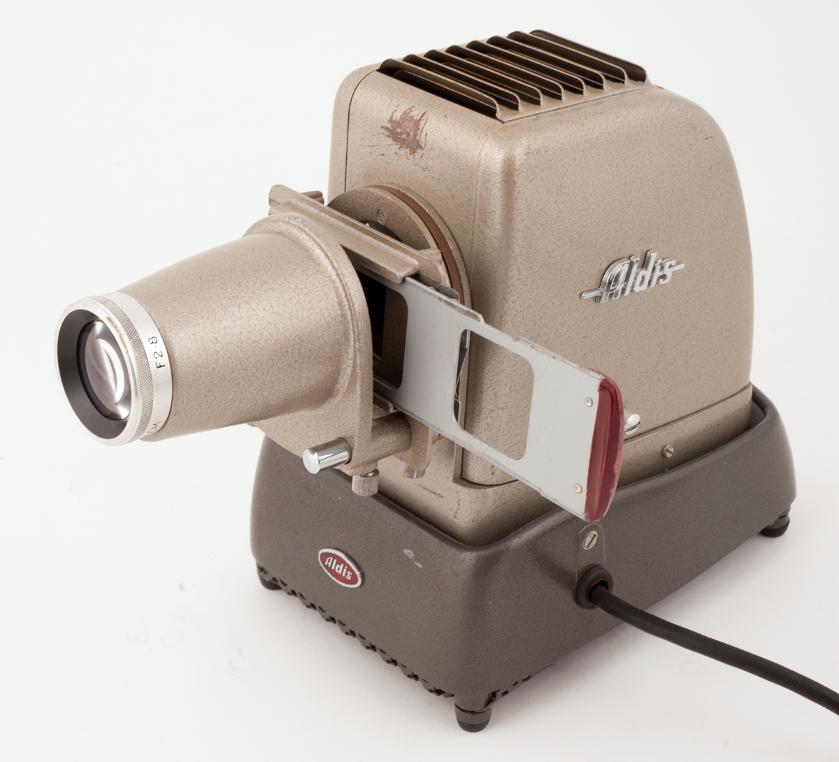 Et lite lysbildeapparat av merke ALDIS med løs skyveholder og holder for rullefilm i låsbar koffert.