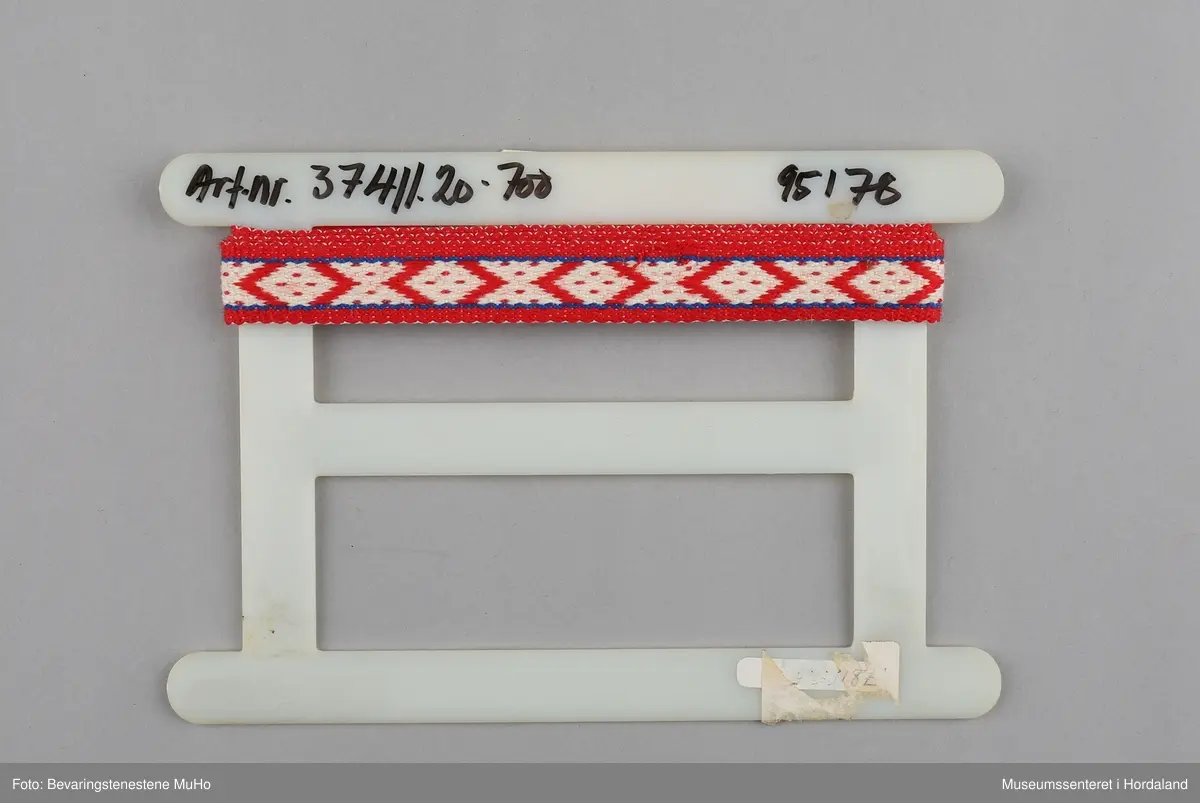 Rull med vevd band, produsert ved bandfabrikken Trengereid Fabrikker i Bergen.