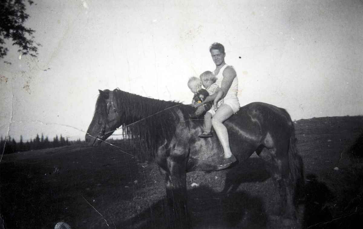 Eivind Bottolf Kristiansen med barna Gunvor og Stein på hesteryggen.